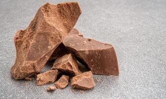 Close up of dark chocolate chunks on a gray surface photo