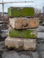 Stack of weathered concrete blocks with green and yellow paint photo