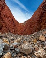 Rocky canyon landscape with red rock walls and a pile of rocks in the foreground photo