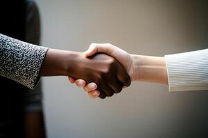 Two people shaking hands over a gray background photo