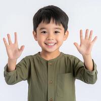 A young boy is smiling and making the sign for five photo