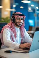 Smiling Arab Man Working on Laptop in Office photo