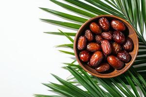 Dates in a Wooden Bowl with Palm Leaves photo