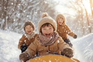 Children enjoying winter fun while sledding down a snowy hill on a sunny afternoon surrounded by trees and falling snowflakes photo