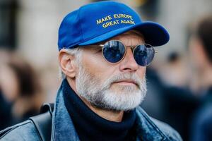 Individual wearing blue cap with Make Europe great again slogan at public gathering, showcasing personal expression amid crowd, highlighting significance of political statements in modern society photo