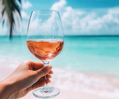 Enjoying a refreshing glass of rose wine by the tropical beach on a sunny day photo
