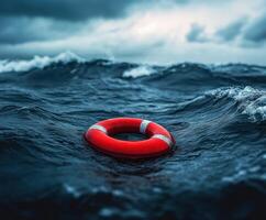 Bright red life buoy floats in turbulent ocean waves under dark stormy sky photo