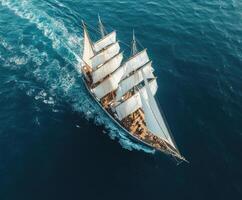 Sailing ship gliding across turquoise waters under bright sunlight in a coastal setting photo