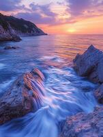 Sunset seascape with cascading waters over rock photo