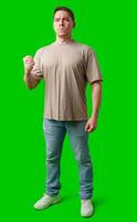 A young man stands confidently in casual attire on a vibrant green background photo