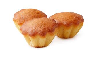 Bakery treats on a white background highlighting three golden mini cakes with a smooth texture photo