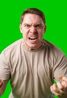 Man expressing intense frustration while standing against a bright green background photo
