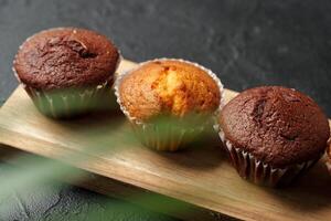 Freshly baked muffins displayed on a wooden board in a cozy setting with soft lighting photo