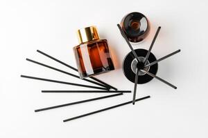 Elegant arrangement of essential oil diffusers with reeds and glass bottles on a minimalist surface photo