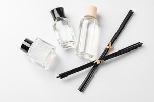 Elegant arrangement of essential oil diffusers with reeds and glass bottles on a minimalist surface photo