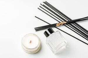 Aromatic essentials including scented candles, incense sticks, and diffusers arranged on a light background photo