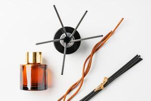 A minimalist display of essential oil and black diffuser sticks on a clean white background photo