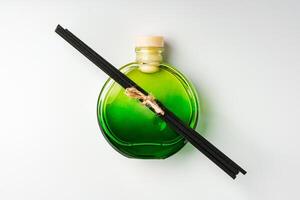 A minimalist display of essential oil and black diffuser sticks on a clean white background photo
