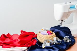 Sewing tools and materials arranged on fabric with a sewing machine in a bright workspace photo