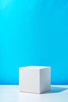 A clean white cube positioned on a minimalist surface against a vibrant blue backdrop photo