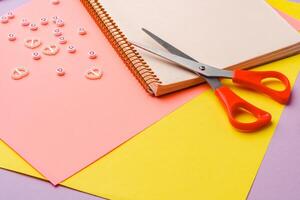 Scissors and decorative tape on colorful craft paper in a bright workspace photo