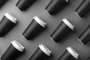 Black disposable cups arranged on a gray surface with white lids, creating a look suitable for a coffee shop setting photo