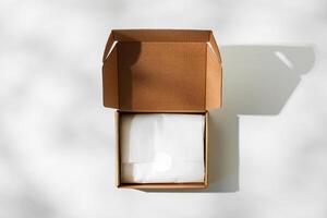 Open cardboard box on a reflective surface with soft shadows photo