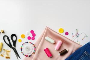 Crafting supplies arranged on a table with fabric, thread and buttons during daytime photo