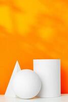 White geometric shapes on a vibrant orange background with soft shadows in a well-lit indoor setting photo