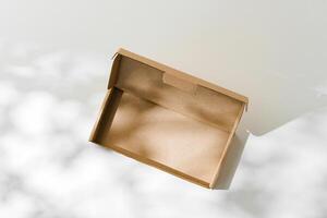 Open cardboard box on a reflective surface with soft shadows photo