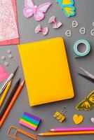 Crafting supplies arranged for a DIY project on a gray table with scissors, washi tape, and decorative items photo