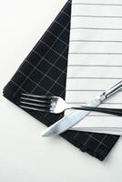 Cutlery placed on contrasting black and white napkins ready for dining at a table setting photo