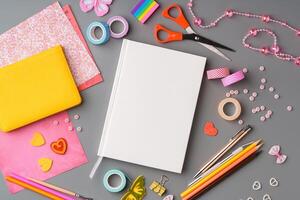 Crafting supplies arranged for a DIY project on a gray table with scissors, washi tape, and decorative items photo