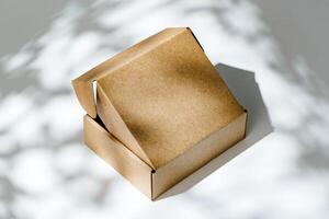 An open cardboard box rests on a bright white surface with soft shadows photo