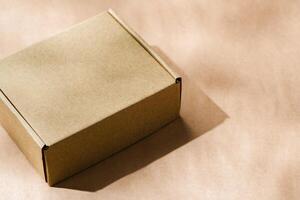 A plain cardboard box on a textured surface with soft light and shadows during the afternoon photo