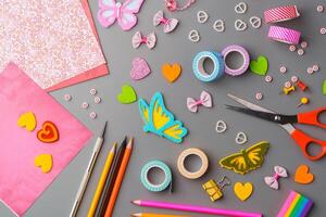 Crafting materials and tools arranged on a gray surface during a creative project photo