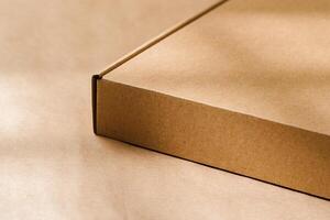 A plain cardboard box on a textured surface with soft light and shadows during the afternoon photo
