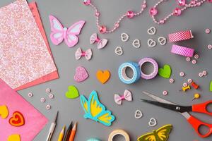 Crafting materials and tools arranged on a gray surface during a creative project photo