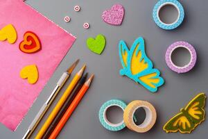 Crafting materials and tools arranged on a gray surface during a creative project photo