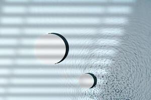 Raindrops create ripples on water surface with shadows from window blinds photo
