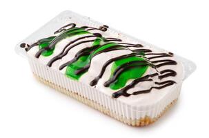 Dessert featuring layers of cream and green gelatin with chocolate drizzle on top in a clear container photo