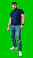Man expressing confusion with crossed arms in front of a bright green background photo
