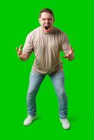 Man expressing intense frustration while standing against a bright green background photo