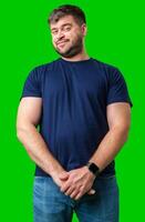 Man standing with a thoughtful expression in a casual outfit against a green background photo