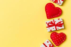 Holiday composition of gift boxes and red textile hearts background with empty space for your design. Top view of Valentine's Day concept photo