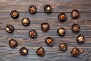 Different kinds of chocolates on colored table Top View and Flat Lay photo