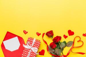 Valentine day composition with Envelope rose and Red heart on table. Top view, flat lay. Holiday concept photo