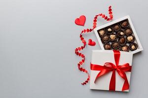 Delicious chocolate pralines in red box for Valentine Day. Heart box of chocolates top view with copy space photo