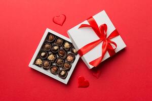 Delicious chocolate in red box for Valentine Day. Heart shaped box of chocolates top view with copy space photo