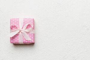 Valentine day composition red gift box with bow and heart. Christmas present. View from above. Space text. Holday greeting card photo